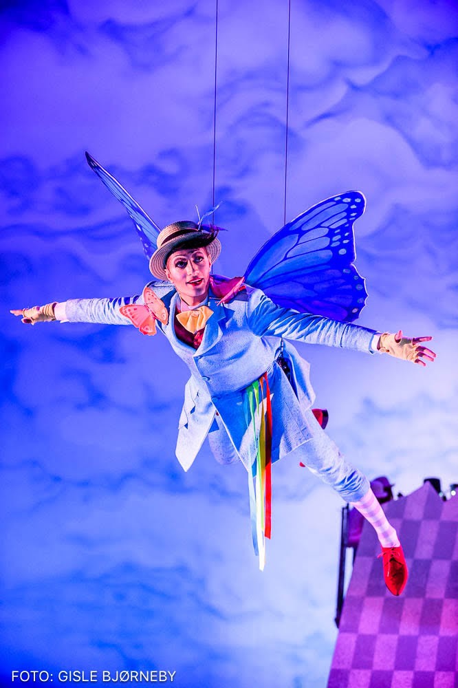 A butterfly played by an actor in a blue costume and yellow hat