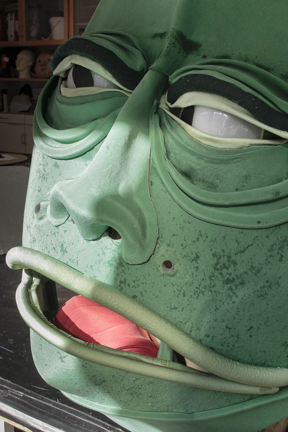 A close up portrait of a green big monster head