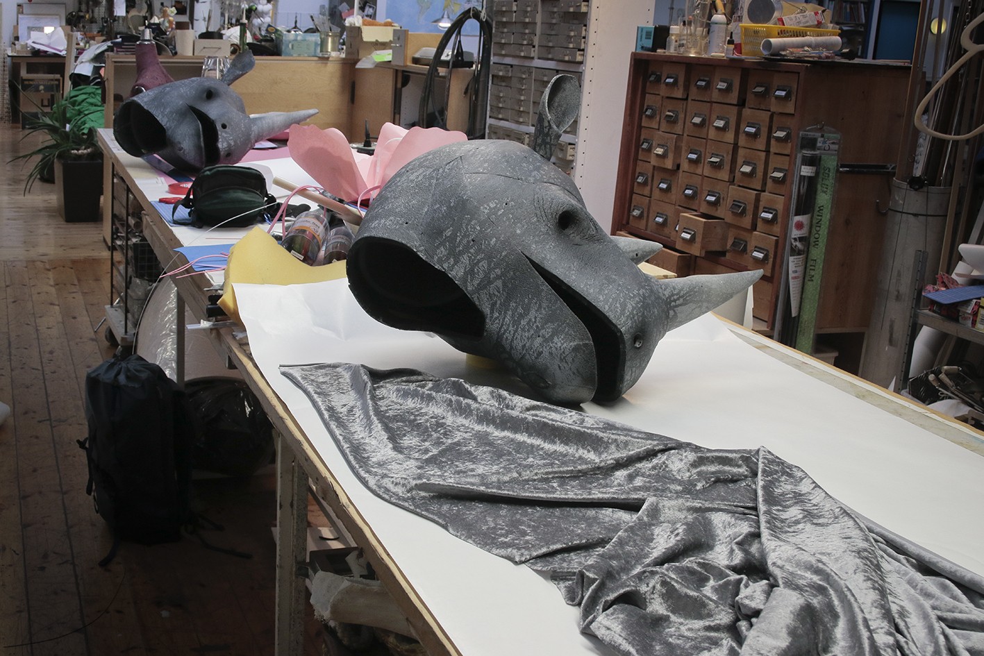 Grey material and two rhinoceros heads at the theatre workshop