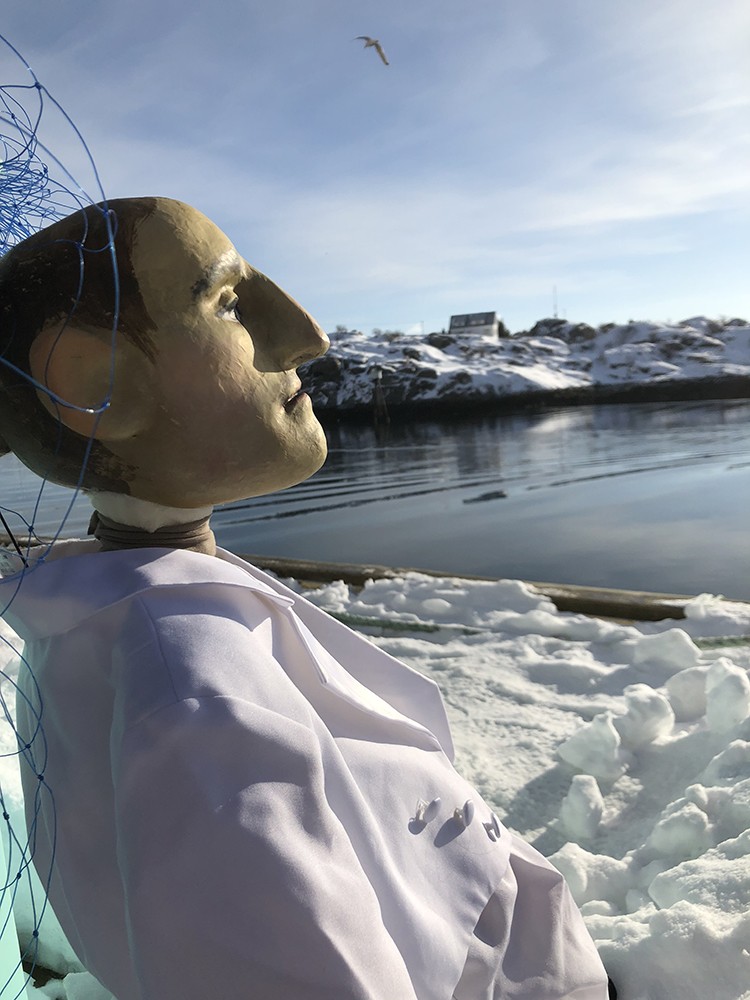 A puppet figure sits on the snow