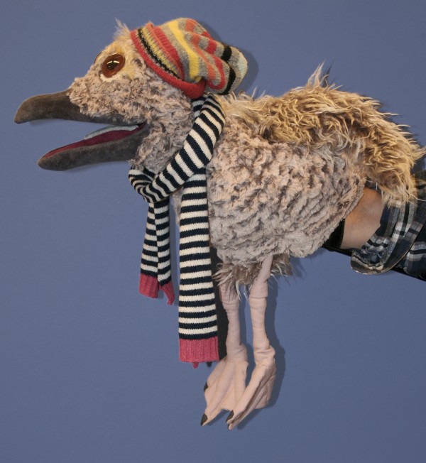 Et profilbilde av måke-dukken iført stripete skjerf og hatt
