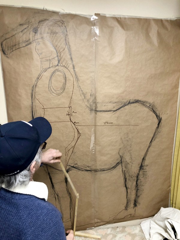 Sean measuring a big donkey sketch.