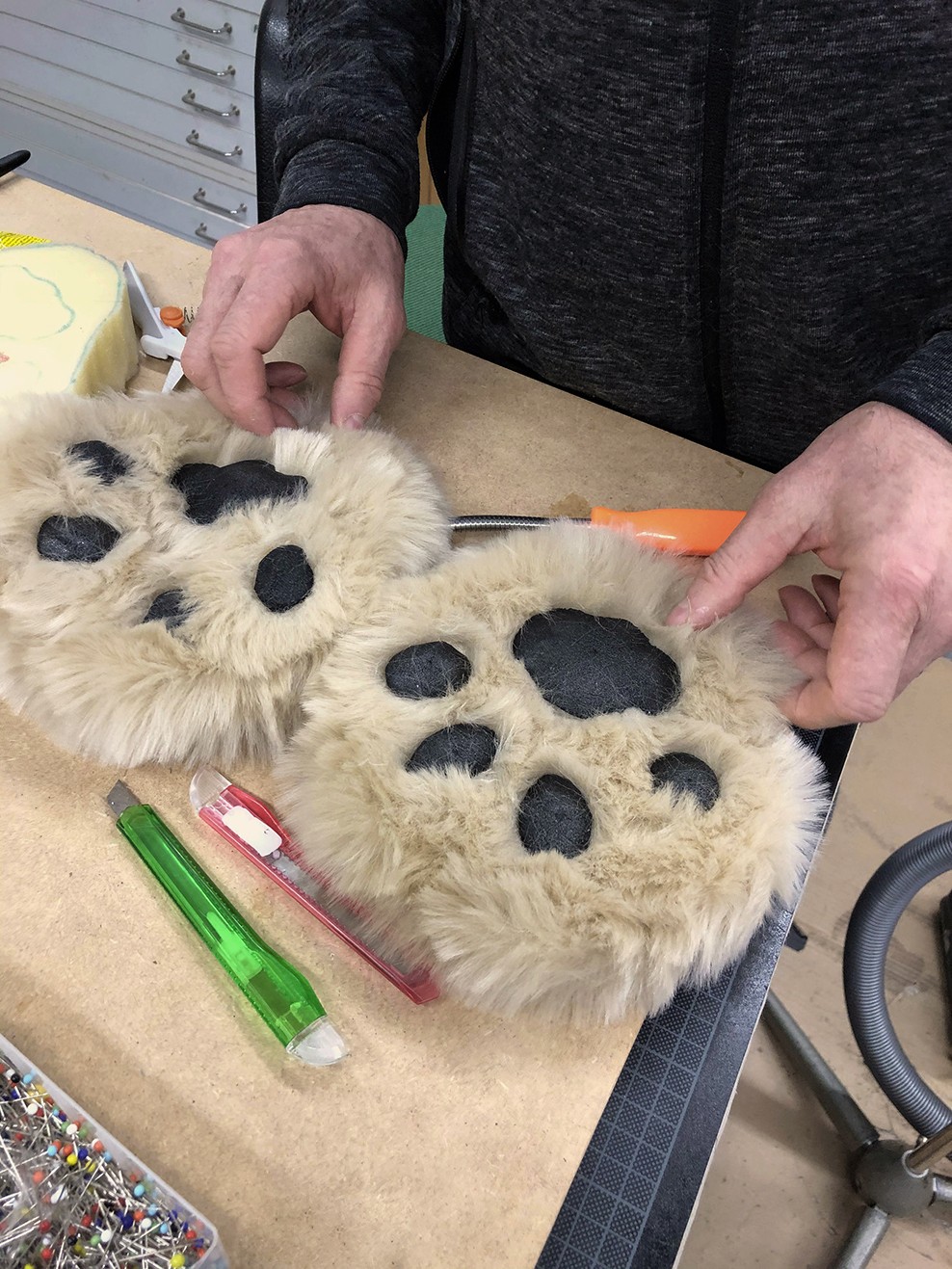 Lion puppet paws on the table.