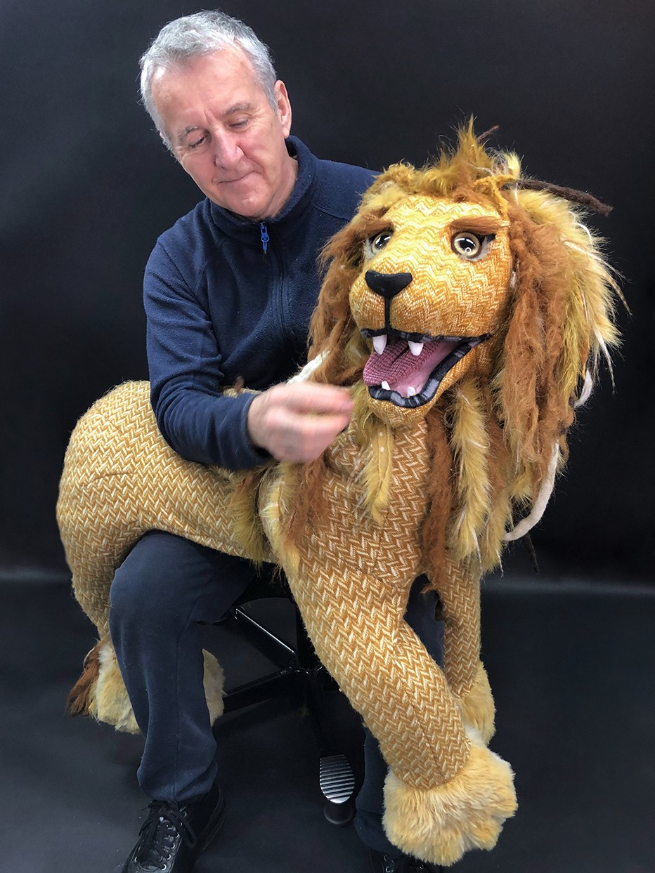 Sean with a lion puppet on his lap.