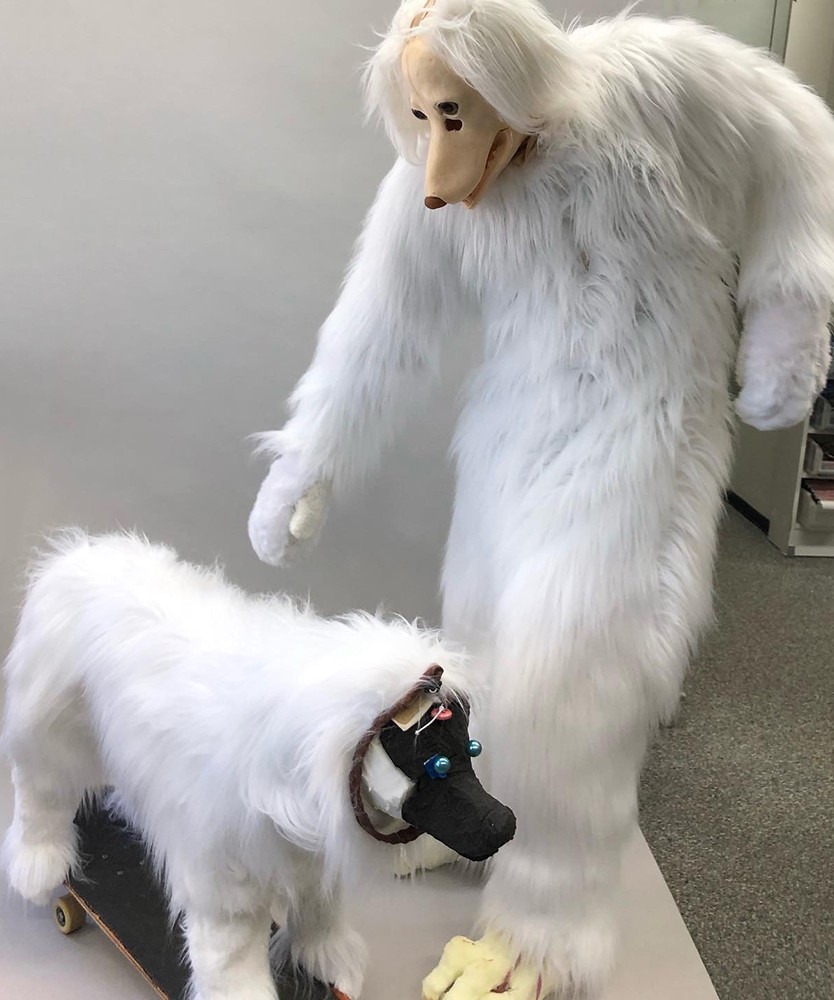 A white fur costume on a dog modell and a person