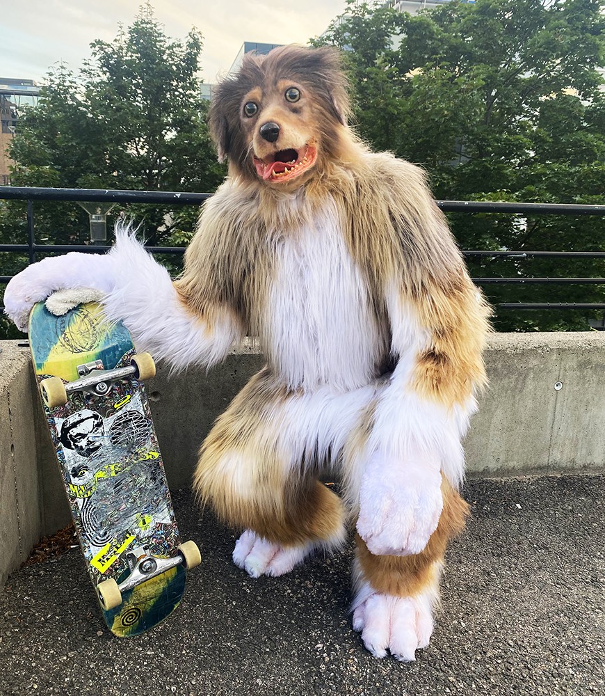 A person in dog costume holds a skateboard