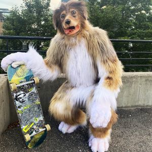 En person i hundekostyme holder en skateboard